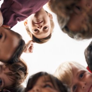 Group of kids students smiling confident standing with heads together at classroom